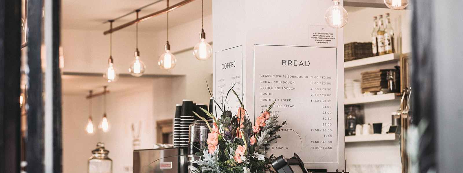 inside the restaurant with pendant lamps and flowers