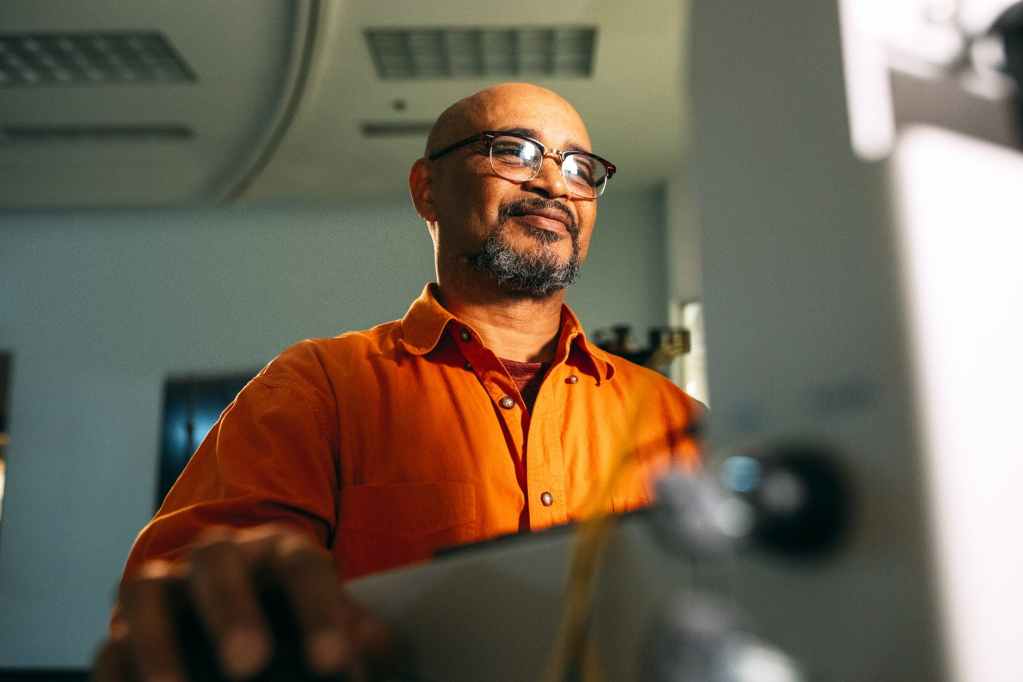 man wearing eyeglasses facing computer