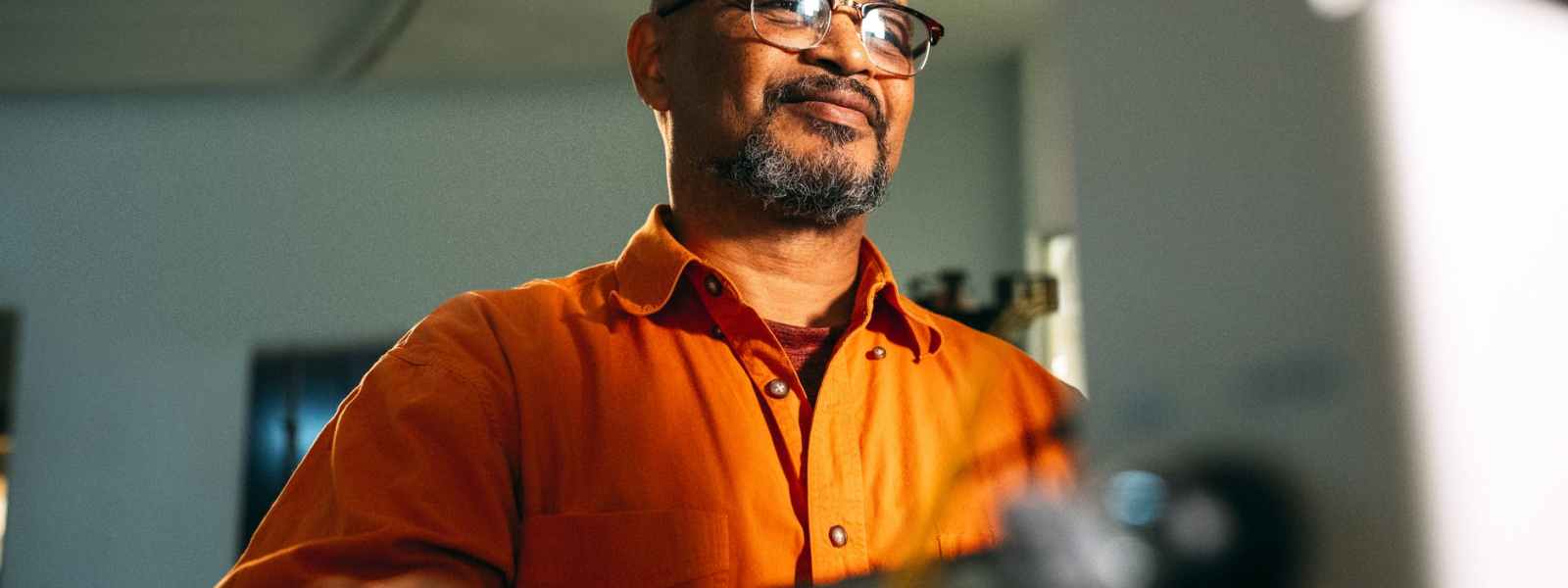 man wearing eyeglasses facing computer