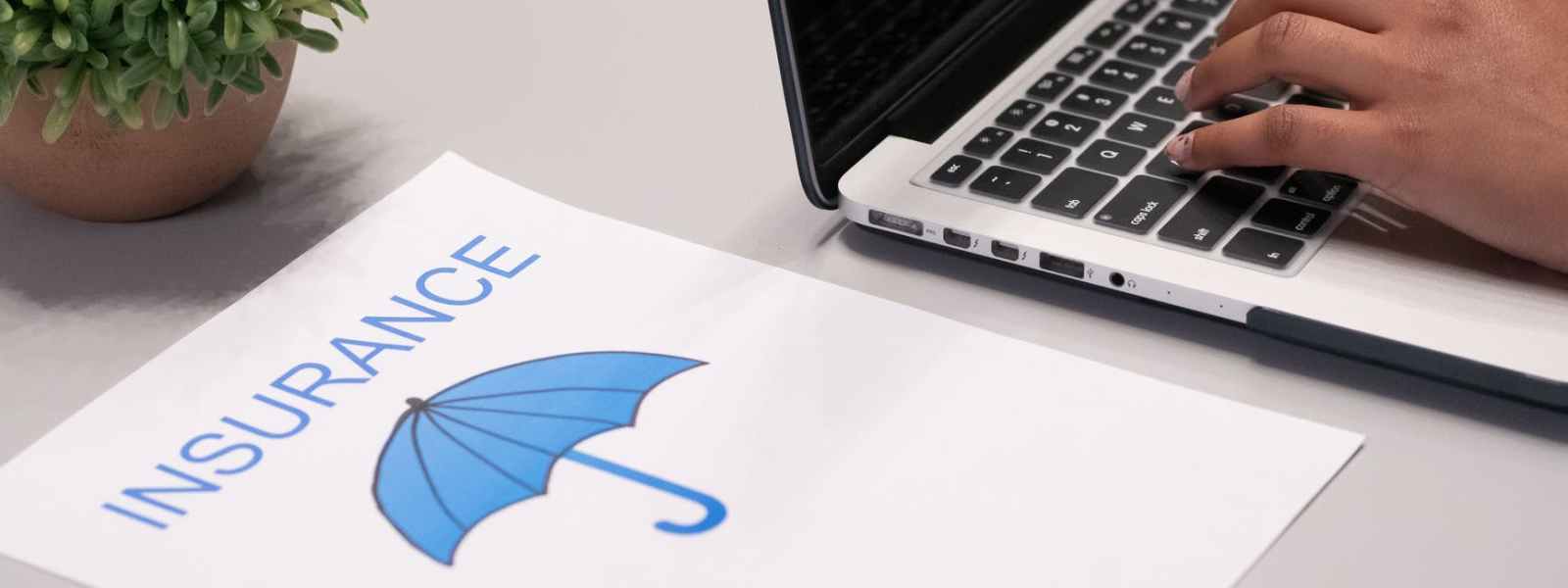 a paper beside a person typing on a laptop