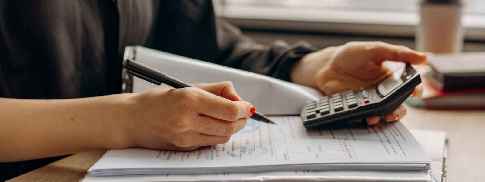 person in long sleeve shirt holding a calculator
