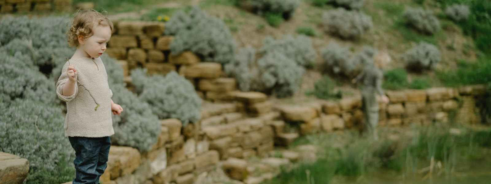 child standing beside a pond