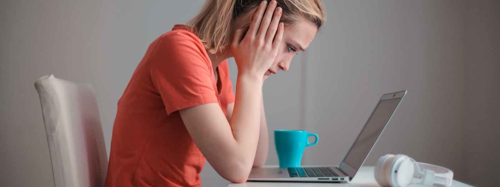 young troubled woman using laptop at home