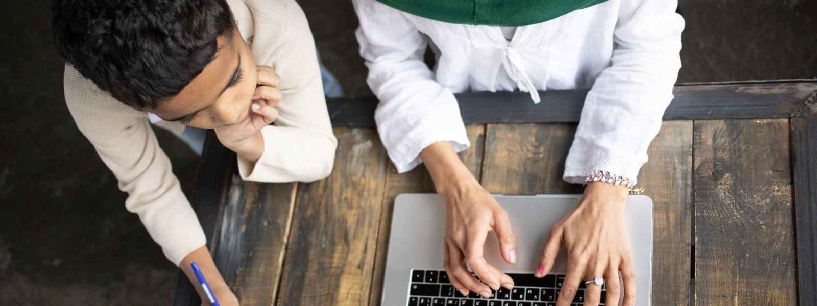 arabian mother in hijab typing report on laptop near son