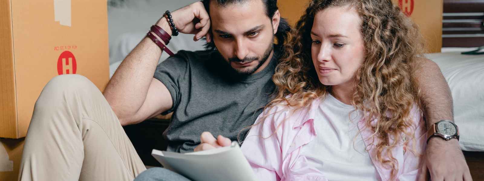 thoughtful couple writing in notebook while moving house