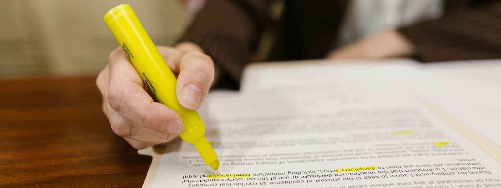 close up shot of a person writing on a contract