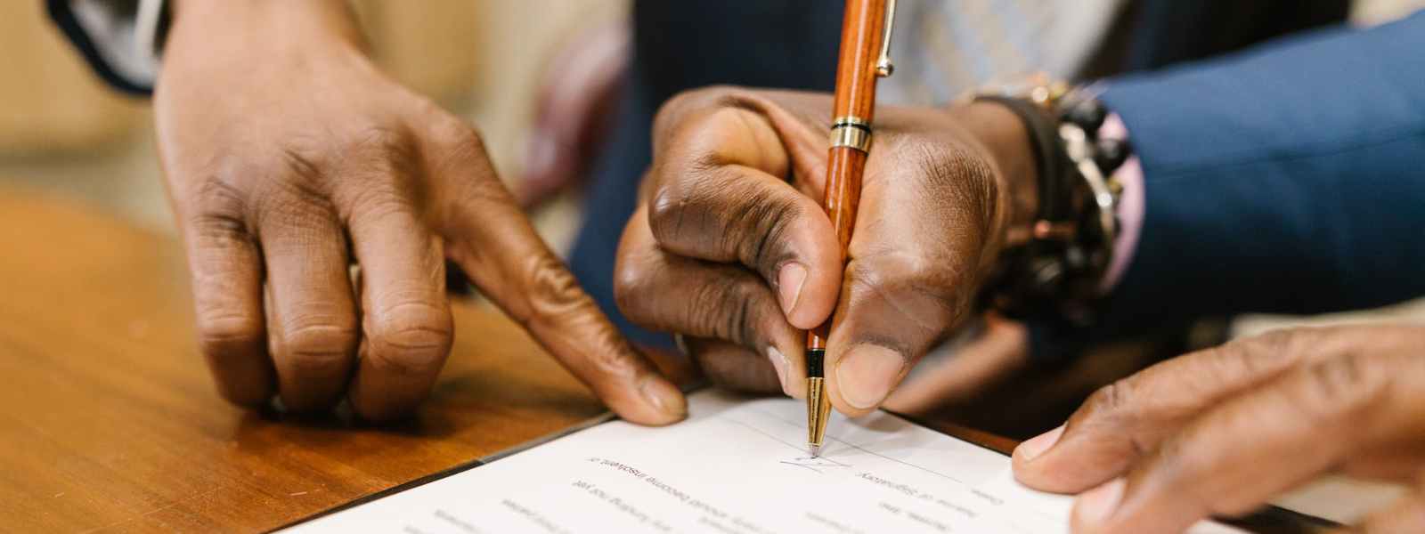 close up shot of a person writing on a contract