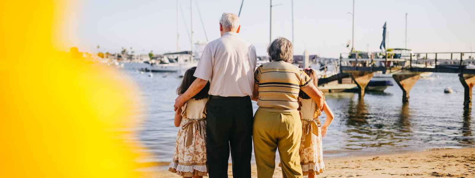 grandparents with their granddaughters standing by the shore