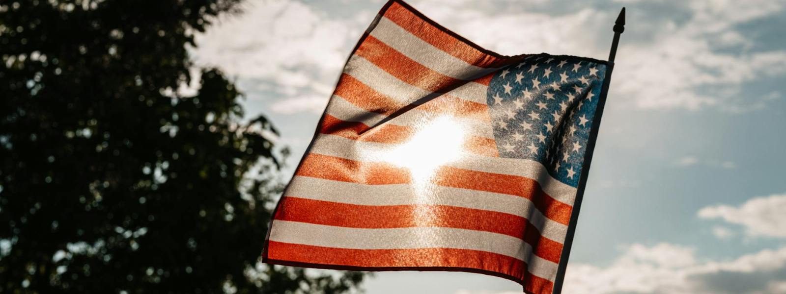 american flag under a cloudy sky