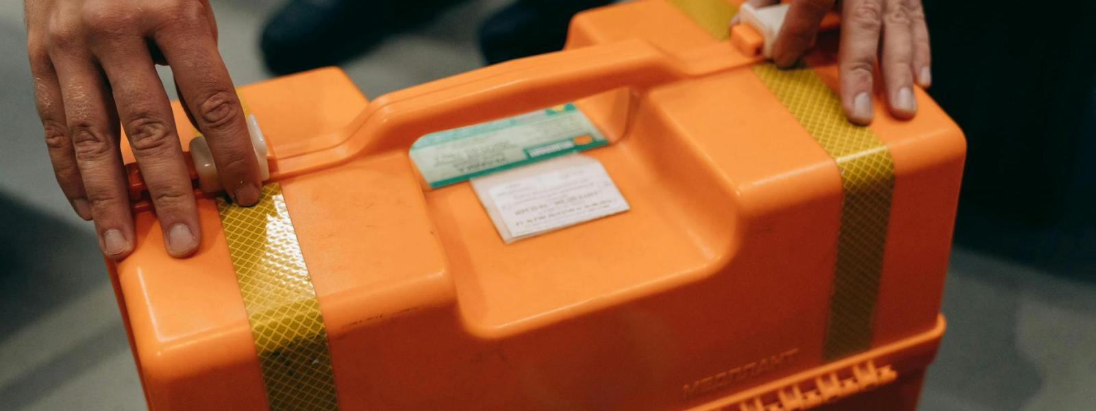 hands on orange hard suitcase